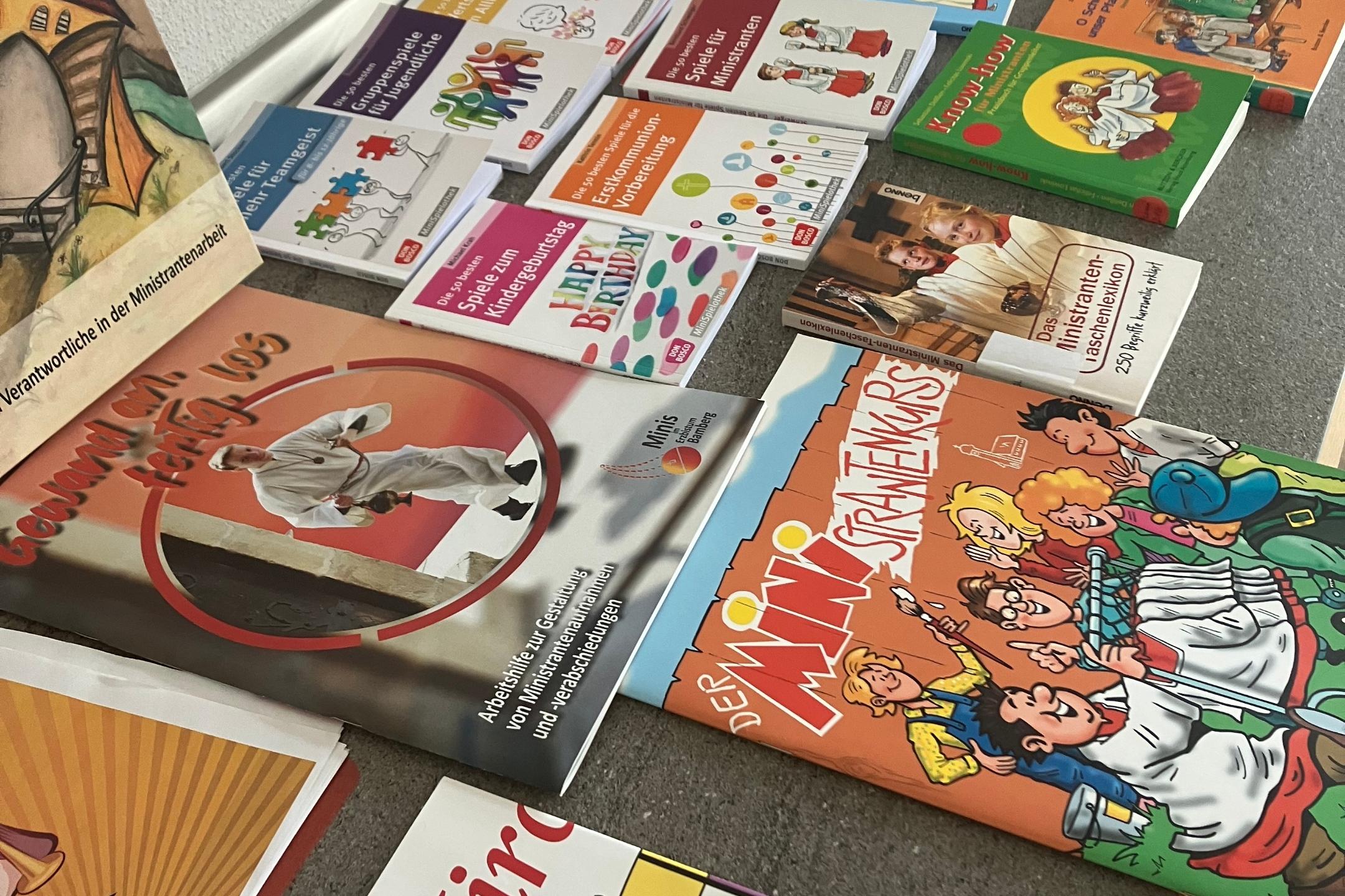 Auf dem Bild sieht man viele Bücher und Broschüren für Mini-Gruppenstunden