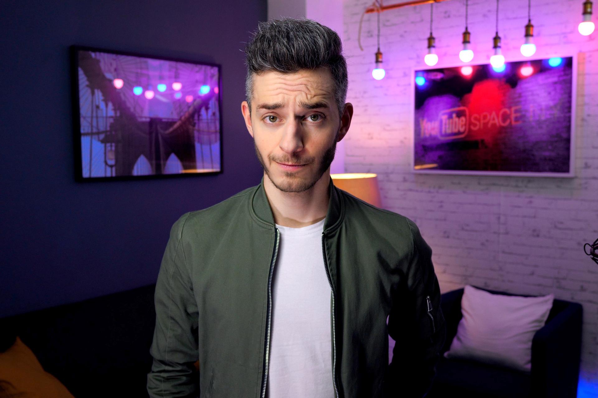 Ein Mann schaut etwas skeptisch in eine Kammeera in einem Zimmer