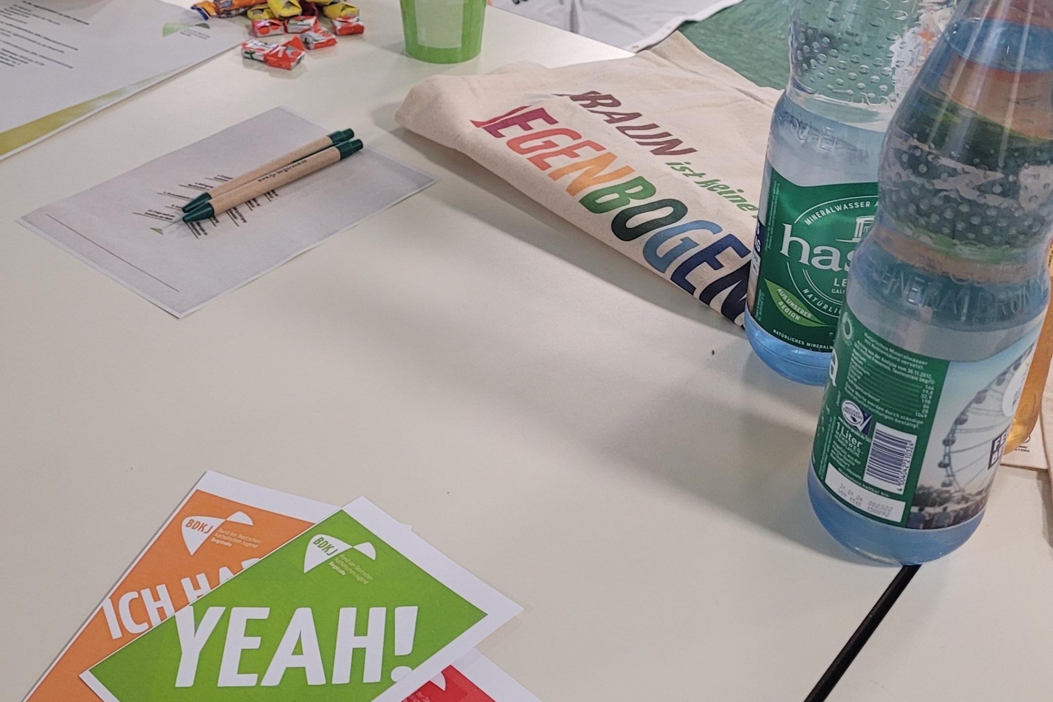 Auf einem tisch liegen grüne, gelbe, rote Karten mit Wasserflaschen.