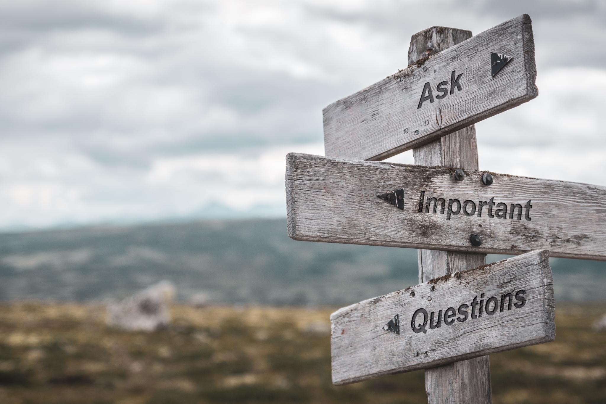 Wegweiser aus Holz der in verschiedene Richtungen zeigt.