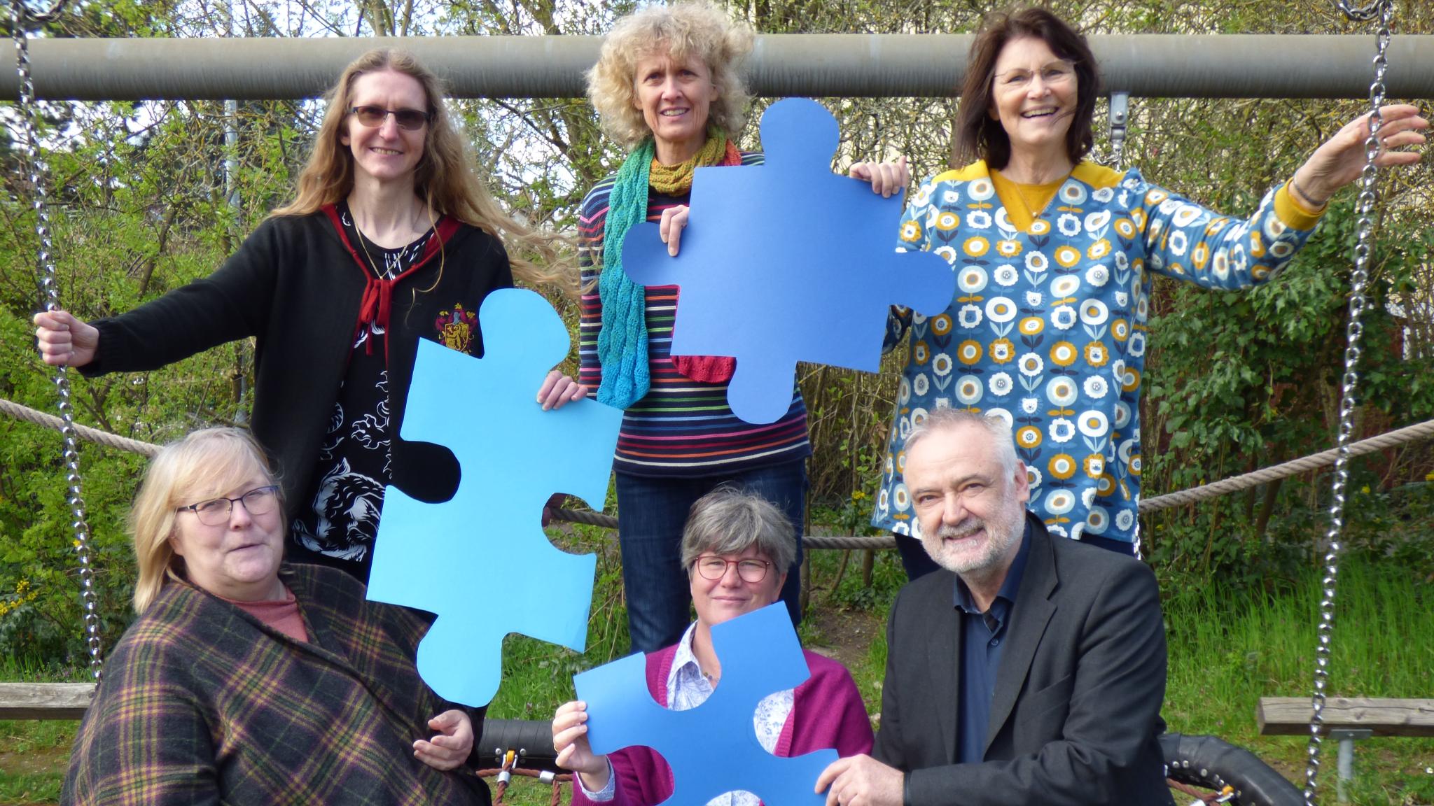 Alle Teammitglieder stehen auf einer Schwalbennest-Schaukel