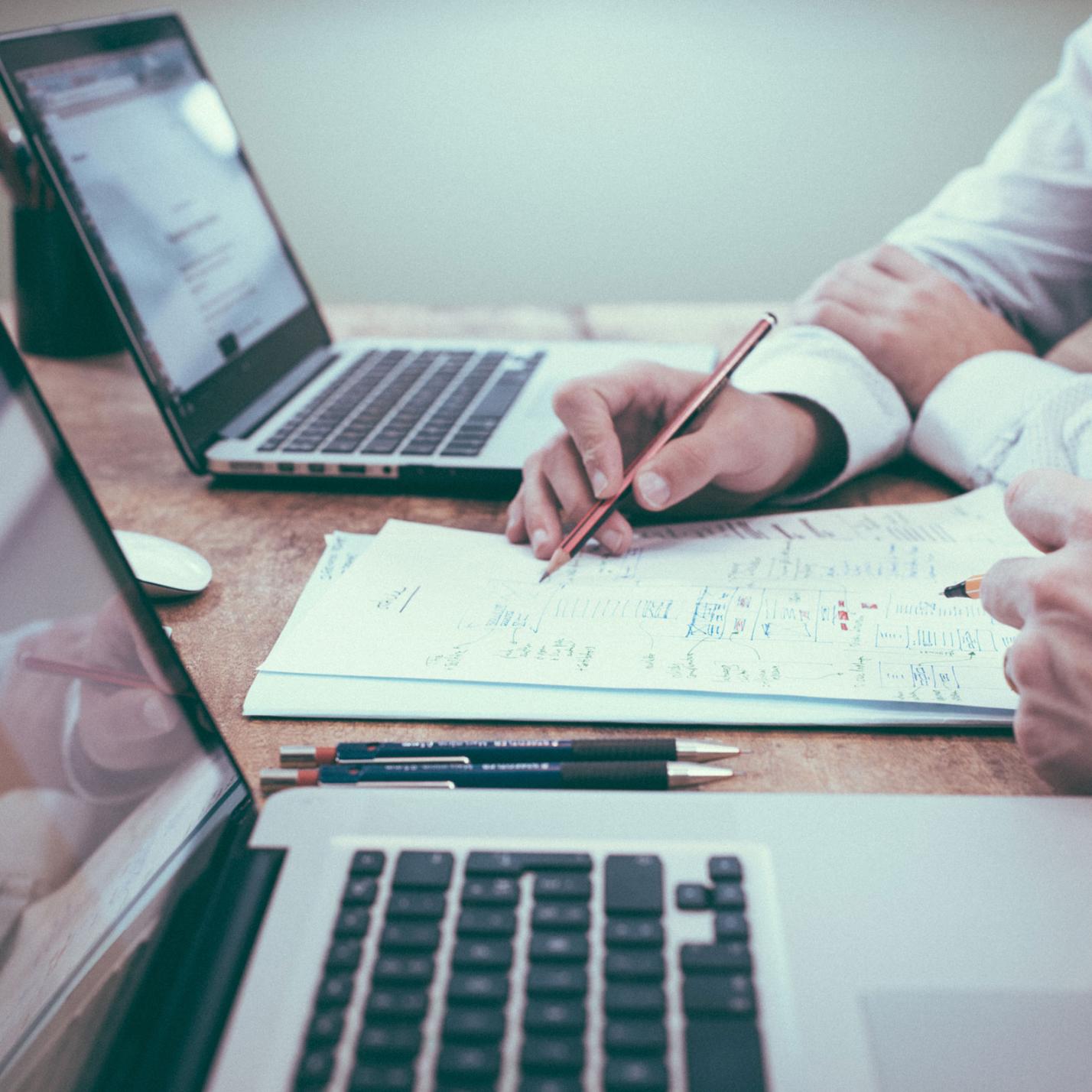 Arbeitstisch mit Laptops und Rechenskizzen (c) helloquence-61189-unsplash Arbeitstisch mit Laptops und Rechenskizzen