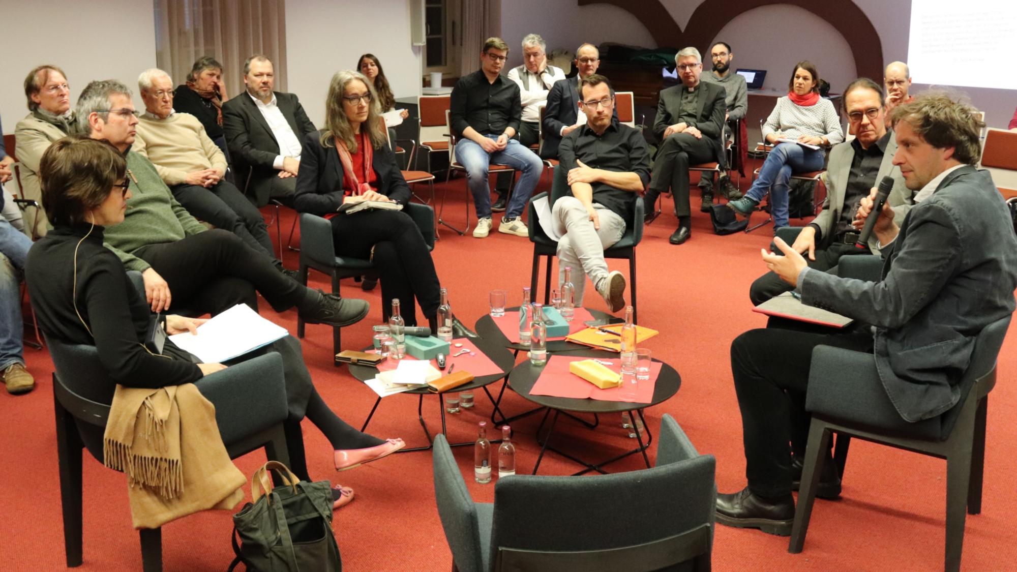 Diskussionsrunde zum Thema Klimakommunikation - vorne im Bild der leere Stuhl für spontan Mitdiskutierende