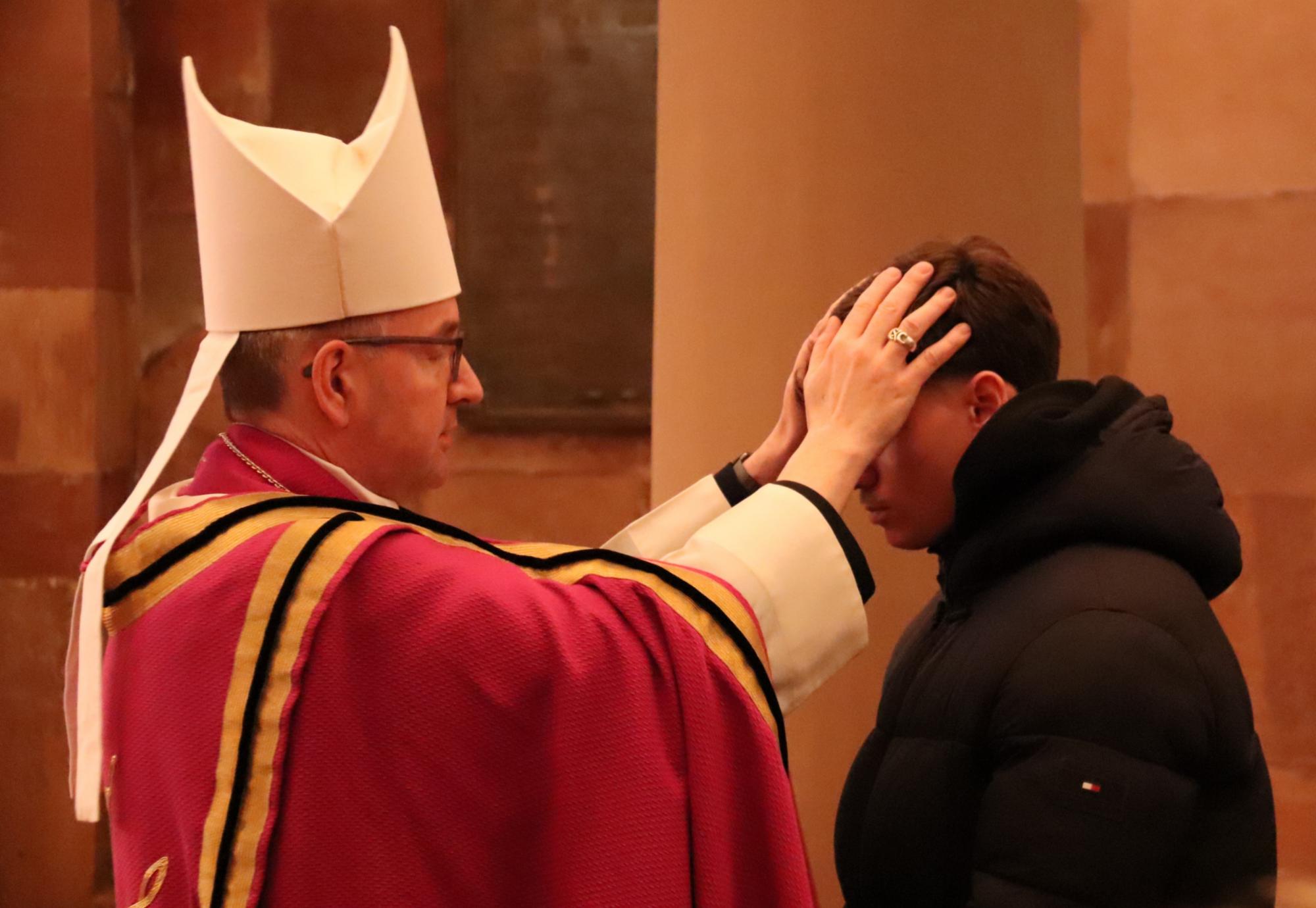 Bischof Peter Kohlgraf legt einem Taufbewerber die Hände auf (c) Bistum Mainz/Hoffmann